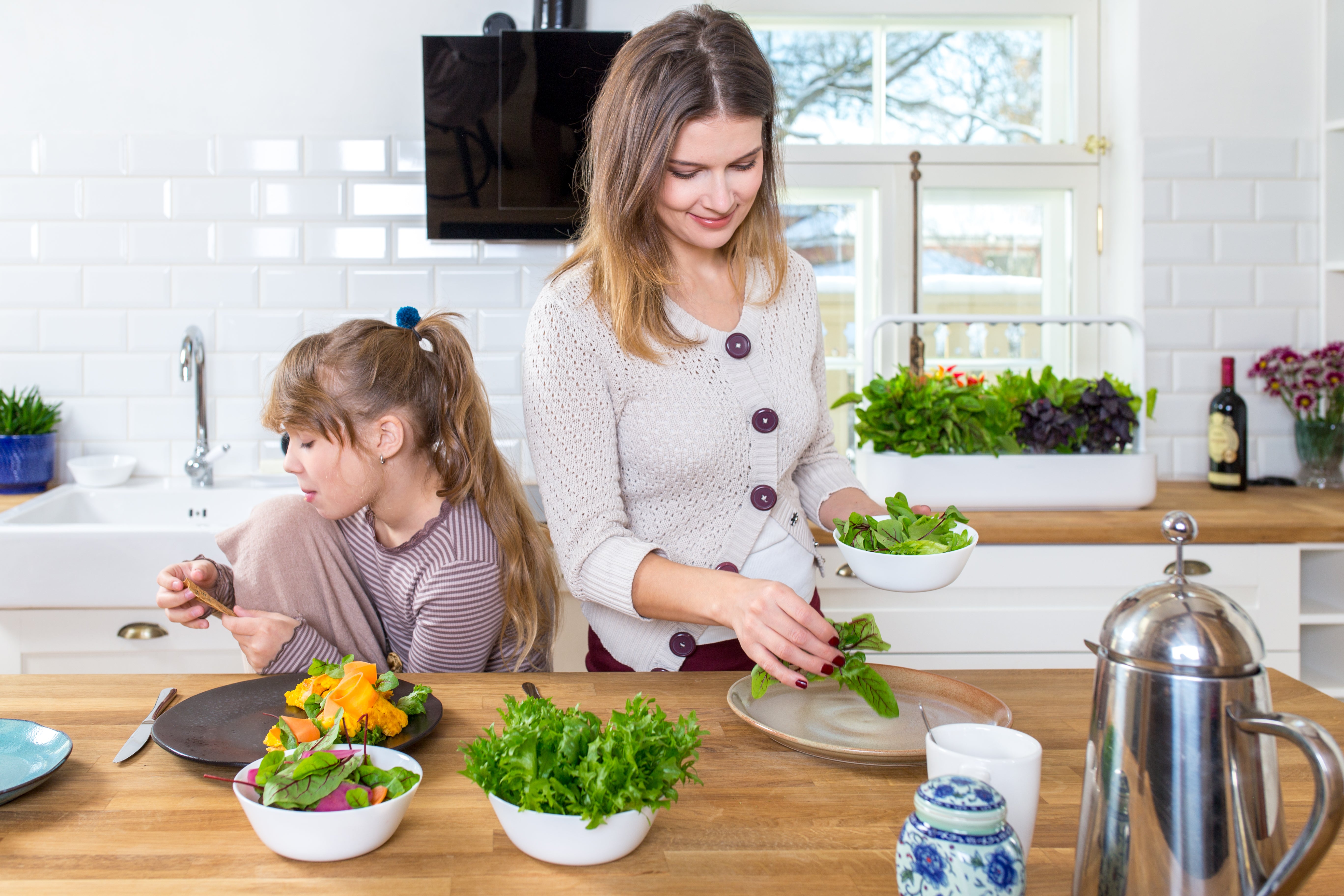 Click & Grow Smart Garden 0 with Woman and child plating greens